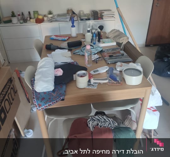 שולחן עם חפצים שונים וארגזים ברקע
